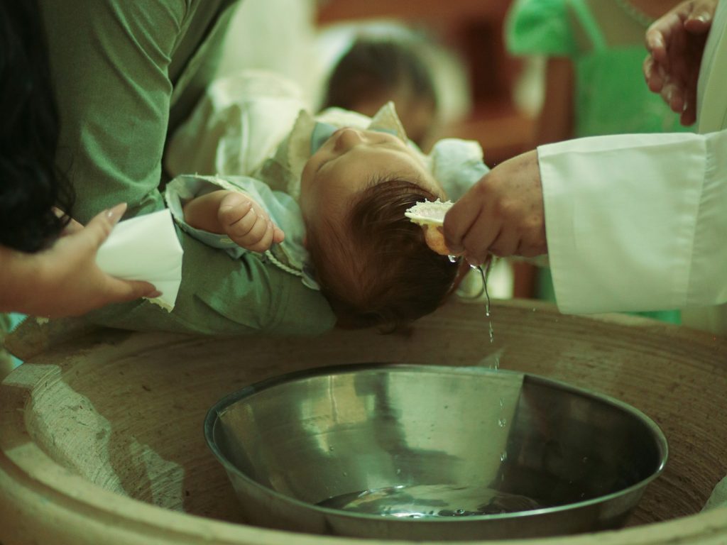 Baby being baptized in a church basin